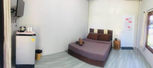 1 dormitorio con 1 cama y nevera pequeña en Rim Lay, en Ko Kood