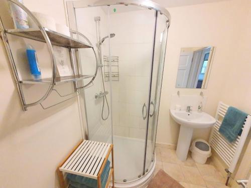 uma casa de banho com um chuveiro e um lavatório. em Bassett Flat with 2 Double Bedrooms and Superfast Wi-Fi em Sittingbourne