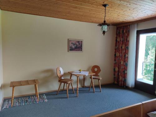 FürsteneckにあるPension Bachlhofの椅子2脚、テーブル、窓が備わる客室です。