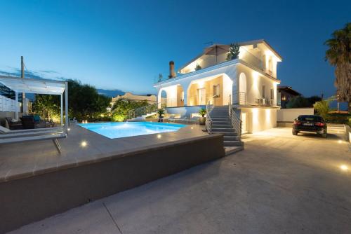 a house with a swimming pool in front of it at Villa Livia - IsulaTravel in Fontane Bianche