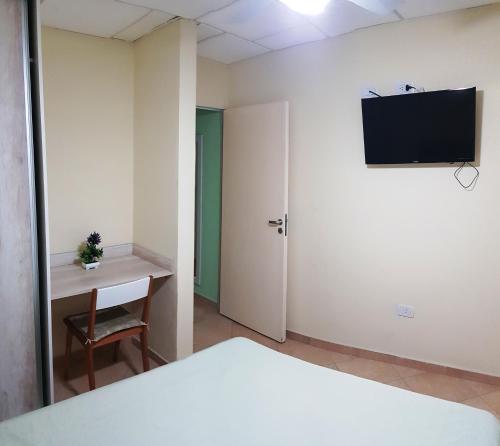 een kamer met een bed, een bureau en een televisie bij TEMPORARIOS CHACO in Resistencia