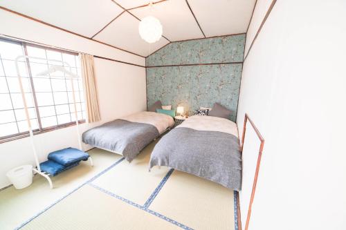a bedroom with two beds and a window at Guesthouse NUI okhotsk #NU1 in Abashiri
