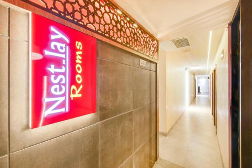 a neon sign on a wall in a hallway at Nestlay Rooms Vanagaram in Chennai