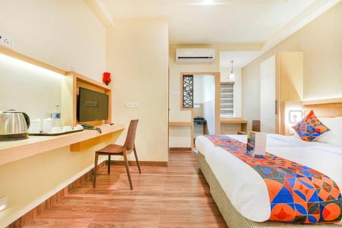 Habitación de hotel con cama y escritorio en Nestlay Rooms Vanagaram, en Chennai