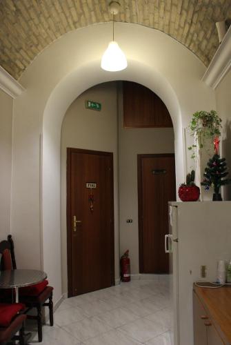 an archway in a room with a table and a refrigerator at Relax On 2 - Guesthouse in Rome