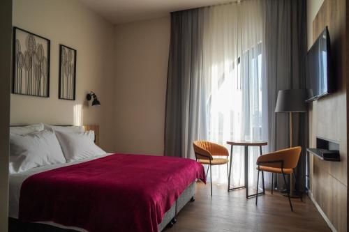 a hotel room with a bed and a table and a window at Apartique Hotel in Jerusalem