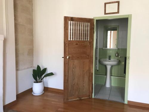 Le Patio d'Arles في آرل: حمام وباب خشبي ومغسلة