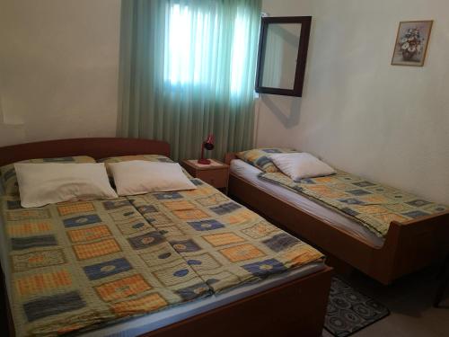 2 camas individuais num quarto com uma janela em Queen beach apartments Nin Sabunike - Green street I em Nin