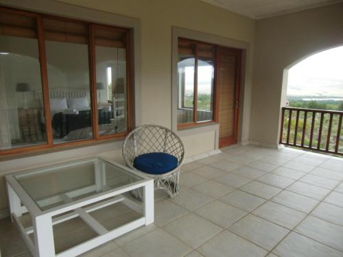 a room with a glass table and a chair at Barton Luxury Villas in Botrivier