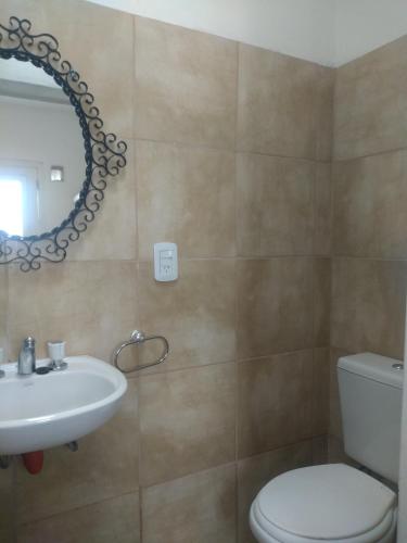 ein Badezimmer mit Waschbecken, Toilette und Spiegel in der Unterkunft Departamento Amoblado in Villa María