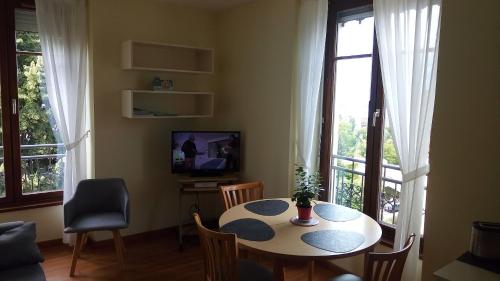 un salon avec une table, des chaises et une télévision dans l'établissement Astay Residence 31, à Aix-les-Bains