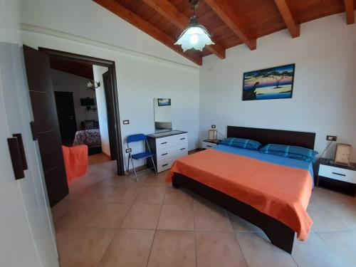 um quarto com uma cama, uma secretária e uma cadeira em Vacanze da Macandu & Stefi em San Giovanni Suergiu