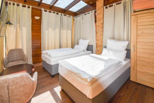 a room with two beds and a chair in it at Boutique Hotel Sena in Berlin