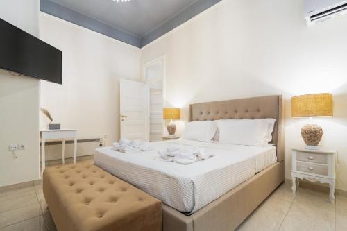 biała sypialnia z dużym łóżkiem z otomaną w obiekcie La Casa di Efi w mieście Rodos