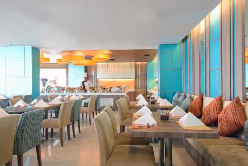 a dining room with tables and chairs and a restaurant at Novotel Bangkok IMPACT in Nonthaburi