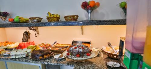 ein Buffet mit Speisen auf einer Theke in einer Küche in der Unterkunft HOTEL ROTA DO SOL in Praia Grande
