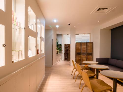a restaurant with tables and chairs and a couch at Apex City Quay Hotel & Spa in Dundee