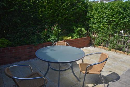 una mesa azul y sillas en un patio en The Alms House en Thetford