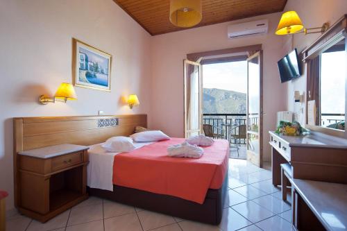 ein Hotelzimmer mit einem Bett und einem Balkon in der Unterkunft Acropole Delphi City Hotel in Delphi