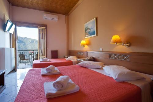 two beds in a hotel room with towels on them at Acropole Delphi City Hotel in Delfoi