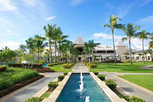 un complexe avec une piscine et des palmiers dans l'établissement Sugar Beach Mauritius, à Flic-en-Flac