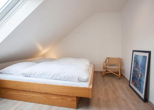 Schlafzimmer mit einem Bett mit weißer Bettwäsche und einer Leiter in der Unterkunft Ferienwohnung Traumblick in Winterberg
