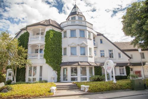 Una gran casa blanca con una torre en la parte superior en Ferienanlage Duhnen, en Cuxhaven