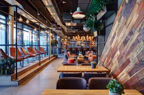a restaurant with tables and chairs and a bar at Me and All Hotel Kiel, by Hyatt in Kiel