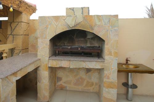 a stone fireplace with a sink in a room at AlZaeem Resort & Hotels in Barka