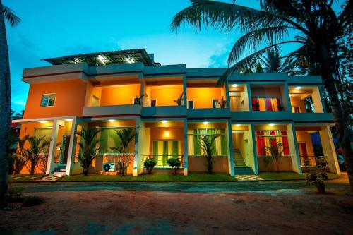 a large house with palm trees in front of it at Vasudevam Premium Suites in Trivandrum