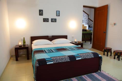 a bedroom with a bed with a blue comforter at Riviera Foothills Duplex Apartment in Arpora