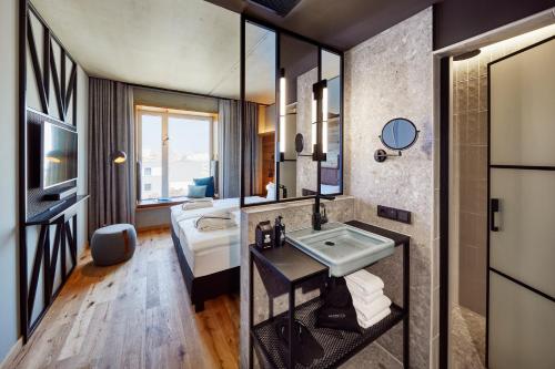 a bathroom with a sink and a mirror at Me and All Hotel Kiel, by Hyatt in Kiel