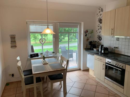 een keuken met een tafel en stoelen en een raam bij Weideblick in Upgant-Schott