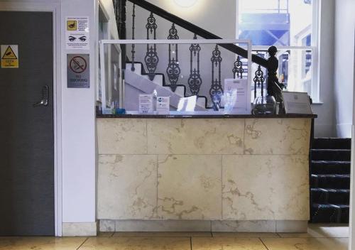 a person standing at a counter in a building at Harrogate Lifestyle Luxury Serviced ApartHotel in Harrogate