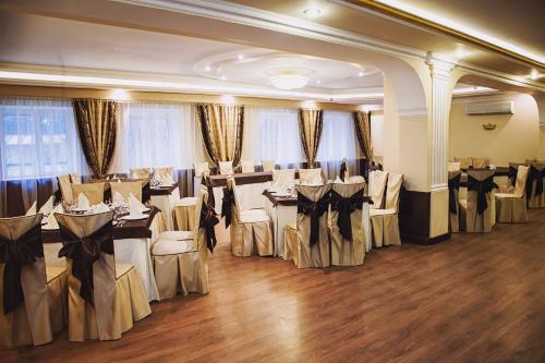 un salón de banquetes con mesas y sillas en una habitación en Mon Plaisir, en Kazán