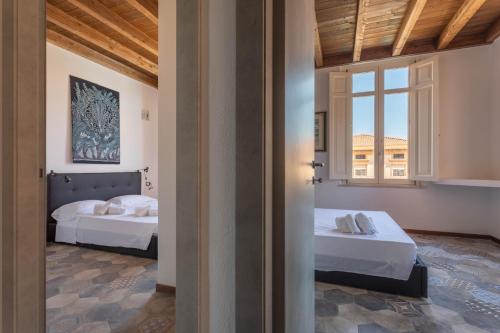 a bedroom with two beds and a window at Maison Belle Époque & suites in Oristano