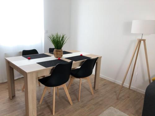 tavolo da pranzo con sedie e pianta di Appartement 6pers spacieux et fonctionnel a Saumur