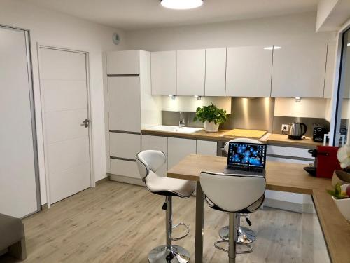 a kitchen with a table with a laptop on it at Brand new studio in the heart of Cannes in Cannes