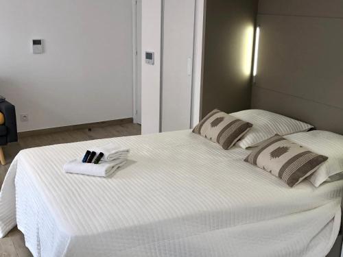 a large white bed with two pillows on it at Brand new studio in the heart of Cannes in Cannes