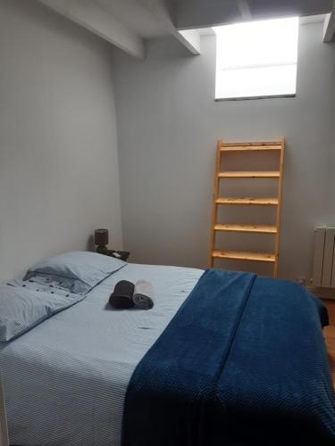 1 dormitorio con 1 cama con manta azul y sombrero en Les Greniers De Blanche, en Le Vivier-sur-Mer