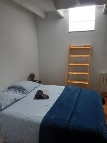 sypialnia z łóżkiem z niebieskim kocem i kapeluszem w obiekcie Les Greniers De Blanche w mieście Le Vivier-sur-Mer