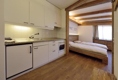 a kitchen with a sink and a bed in a room at Chesa Madrisa in St. Moritz