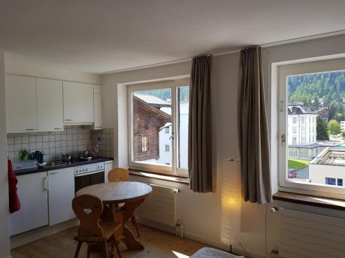 a kitchen with a table and two windows and a table at Chesa Madrisa in St. Moritz
