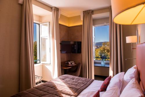 a hotel room with a bed and a window at Impérial Palace in Annecy