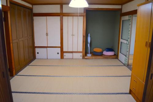 Duży pokój z białymi szafkami i pokój z podłogą w obiekcie Okhotsk House Sattsuru w mieście Kiyosato