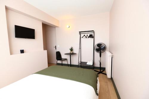 1 dormitorio con cama, mesa y espejo en Appartement spacieux, Paris en 20min, Orly en 20min, Disney en 30min, en Massy