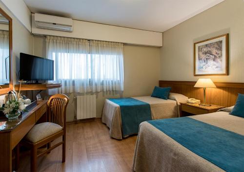 a hotel room with two beds and a television at Hotel Solans Presidente in Rosario