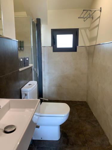a bathroom with a white toilet and a sink at L'Heura in Navata