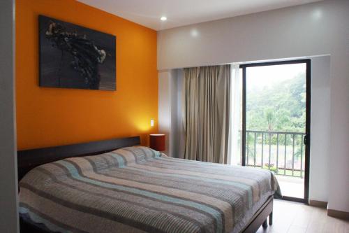 a bedroom with a bed and a large window at Luxury Condo Jaco Beach in Jacó