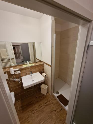 y baño con lavabo blanco y ducha. en Hotel & Gasthof zur Post, en Neumarkt-Sankt Veit